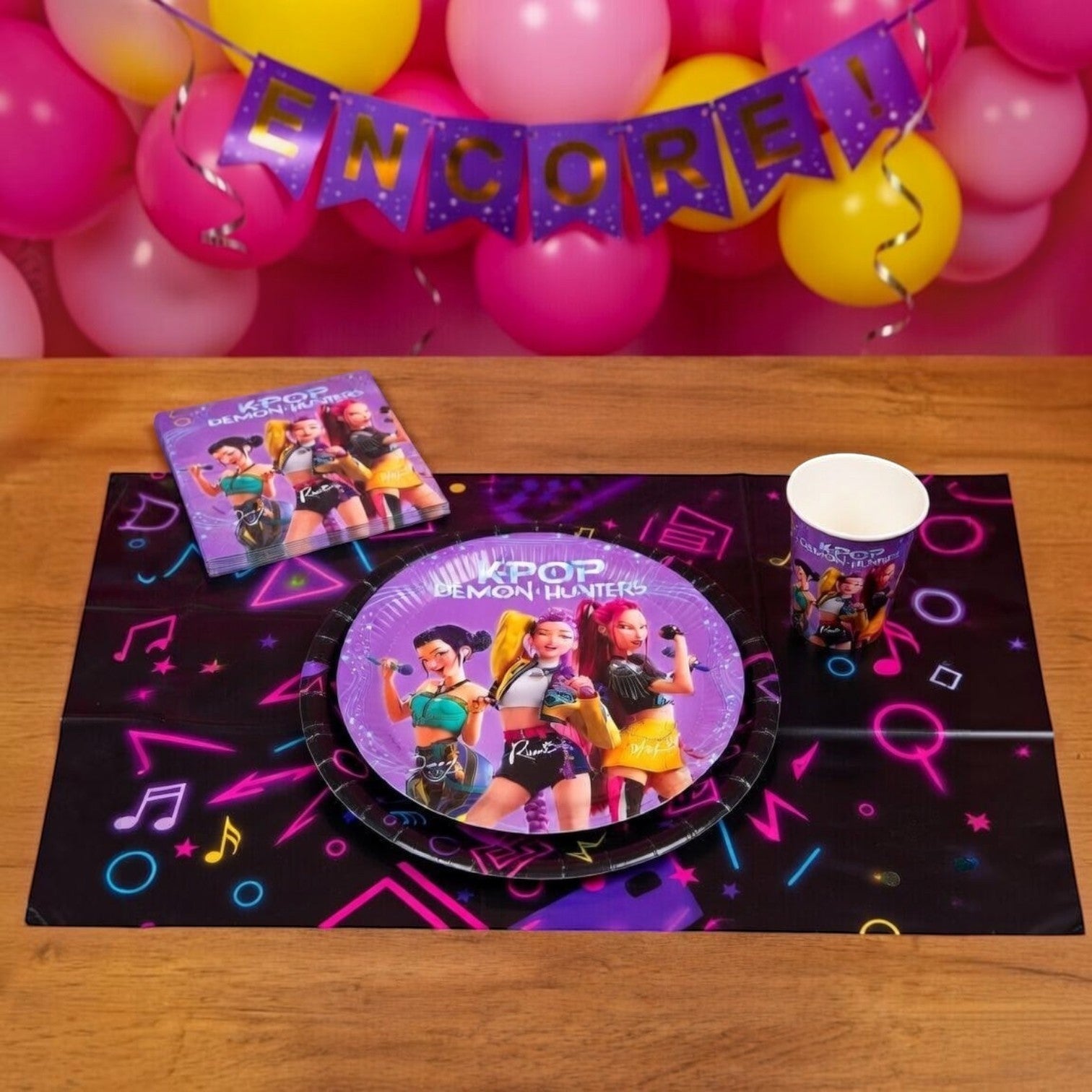Kit anniversaire Le Studio Fantastique K-Pop Demon Hunters avec assiettes, gobelets et serviettes sur table en bois